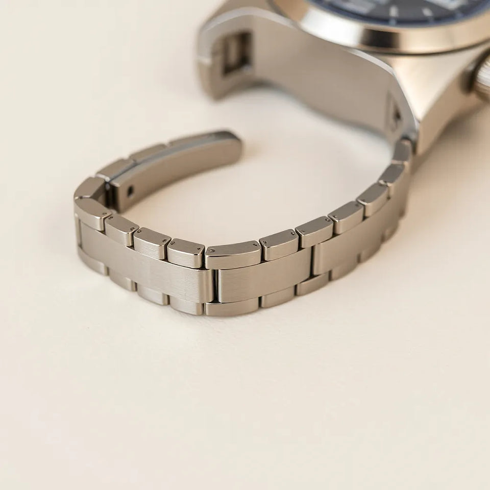 Polished stainless steel watch bracelet band with visible link texture and brushed finish