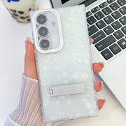 For Samsung Galaxy S25+ 5G Plating Glitter Texture Fold Holder TPU Phone Case with Lens Film(White Shell Pattern)