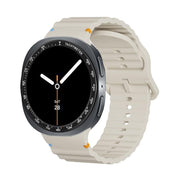 For Samsung Galaxy Watch8 44mm Speed Bezel and Wavy Grain Stitched Color Buckle Silicone Watch Band(Beige Black)
